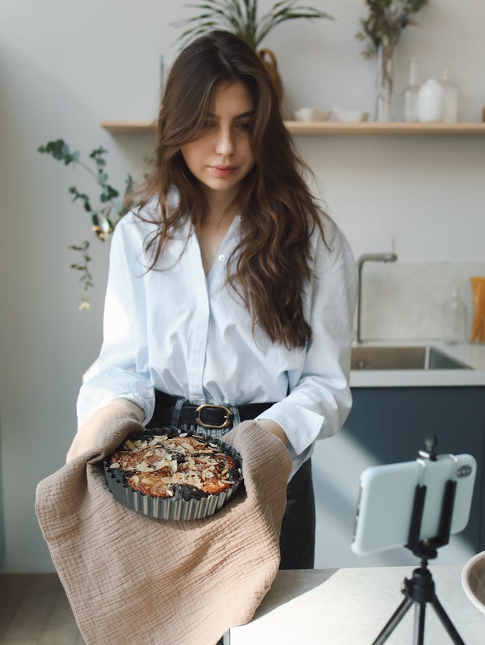 gallery-3 Young woman holding freshly baked goods, filmed in a modern kitchen setting.